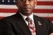 Lt. Col. Allen West arms folded stood in front of USA flag