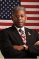 allen-west Lt. Col. Allen West arms folded stood in front of USA flag
